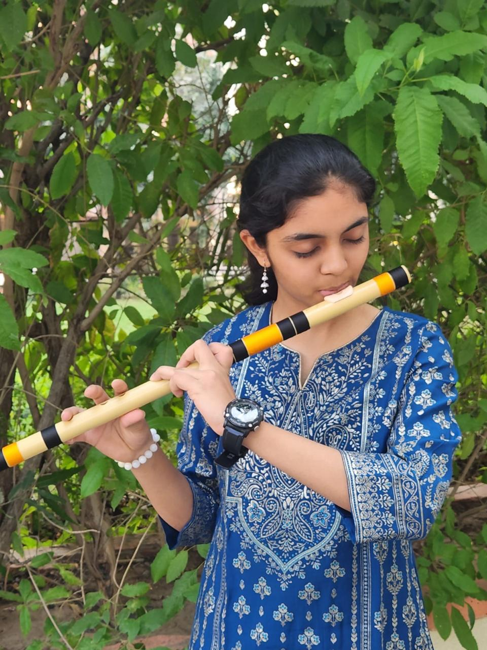 Kashvi playing the bansuri flute outdoors